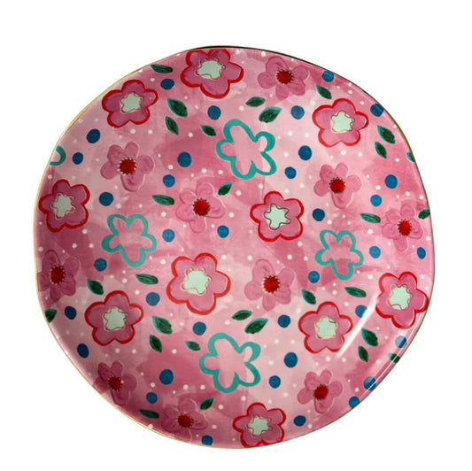 Round pink plate with floral pattern on a white background