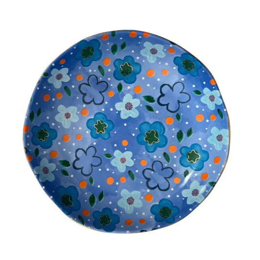 Round blue bowl with floral pattern on a white background
