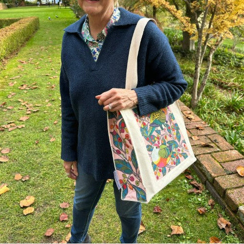 Person holding a colorful tote bag in an outdoor setting