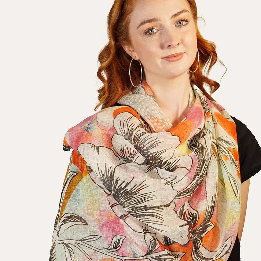 Soft Linen Scarf by Tradition Textiles - Black Floral Design on Orange, Pink, and White Background."