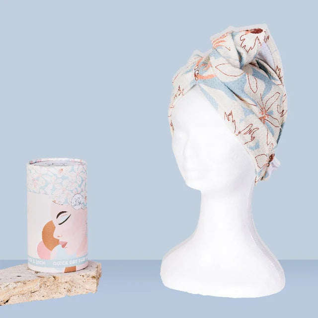 Floral headband and cylindrical product on a mannequin head against a light blue background