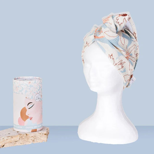 Floral headband and cylindrical product on a mannequin head against a light blue background