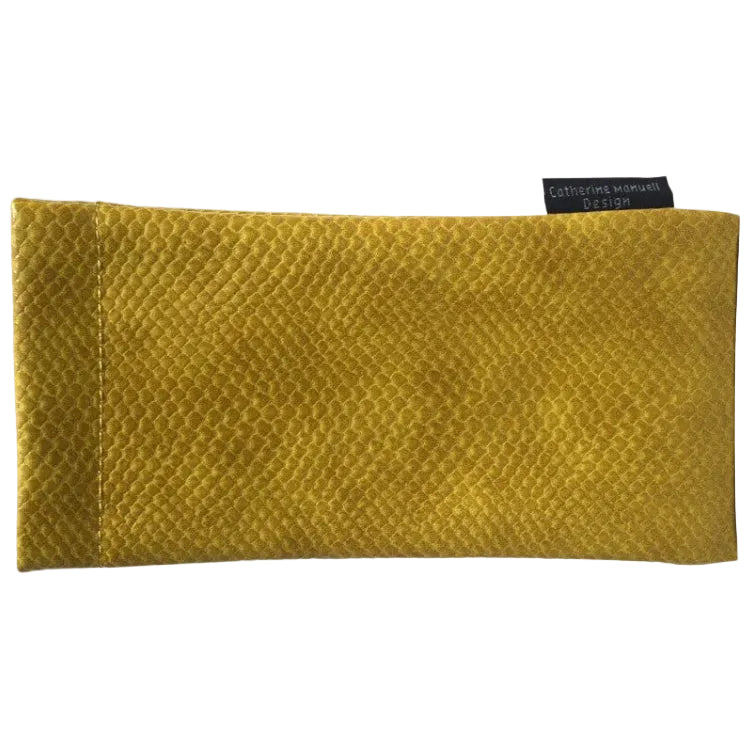 A mustard yellow textured glasses pouch with a small black brand tag reading 'Catherine Manuell Design' on a plain white background.