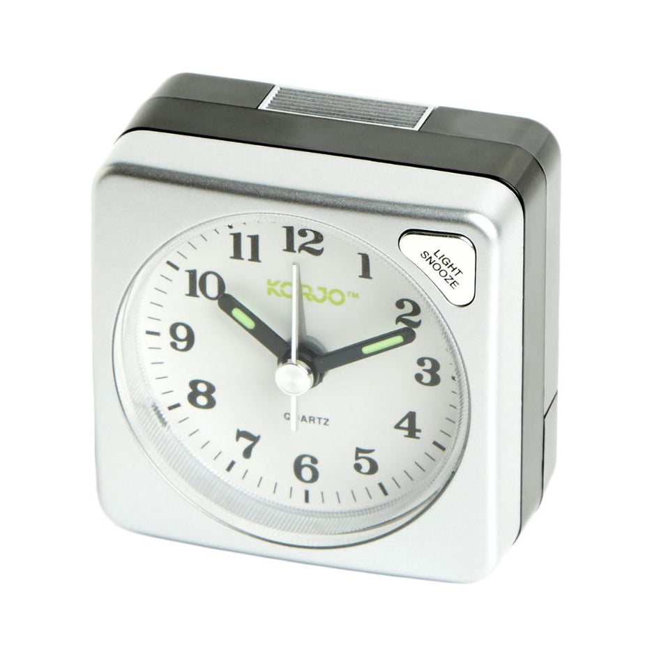 Silver alarm clock with white face on a white background