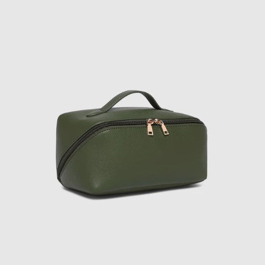 Green toiletry bag with gold zippers on a light gray background