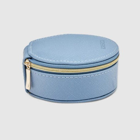 Round blue jewelry case with gold zipper on a light gray background