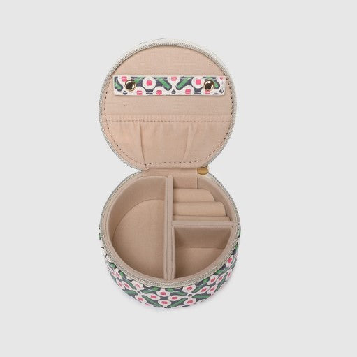 Small round jewelry case with floral design on a light gray background