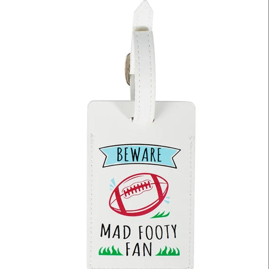 A white leather luggage tag with a printed graphic that reads 'BEWARE MAD FOOTY FAN' alongside a red football illustration, shown on a plain white background.