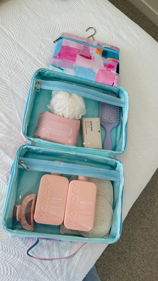 Makeup bag with cosmetic items on a bed