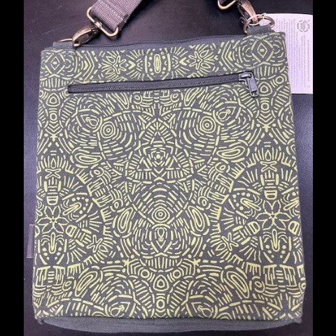 Green patterned bag with a strap on a dark surface
