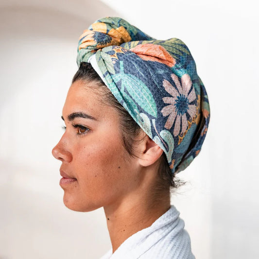 Woman wearing a colorful floral quick dry head wrap.  Front view.