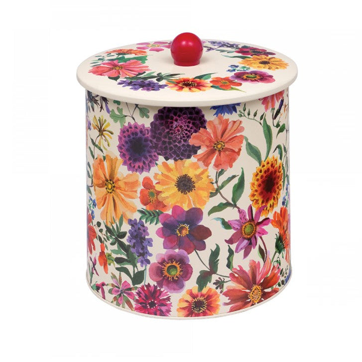 A cylindrical tin canister with a matching lid, decorated with a vibrant multicolor floral pattern on a white background, featuring a small red spherical knob on top.