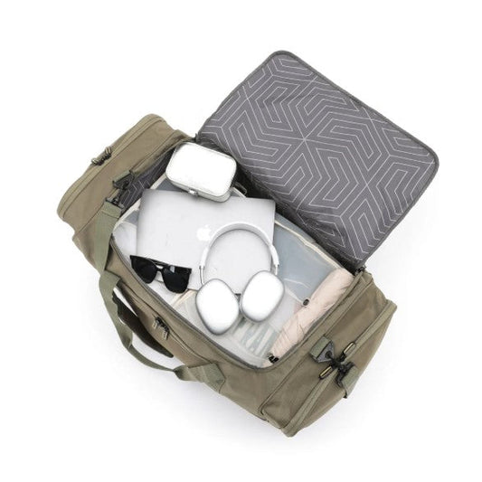 Open green travel bag with gray interior showing sunglasses, white shoes, and a beige item on a white background