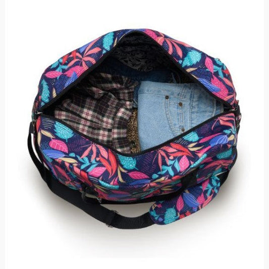 Colorful floral-patterned bag with clothes inside on a white background