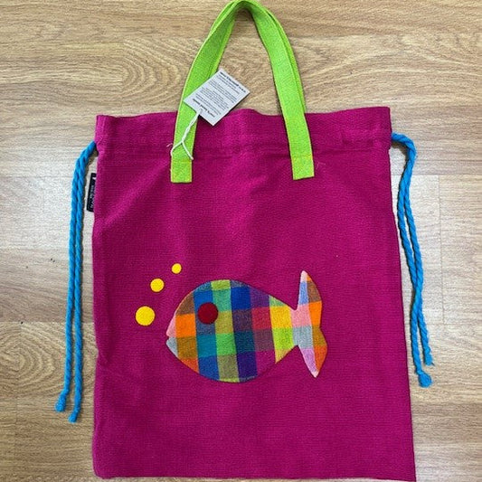 Pink drawstring bag with a colorful fish design on a wooden surface