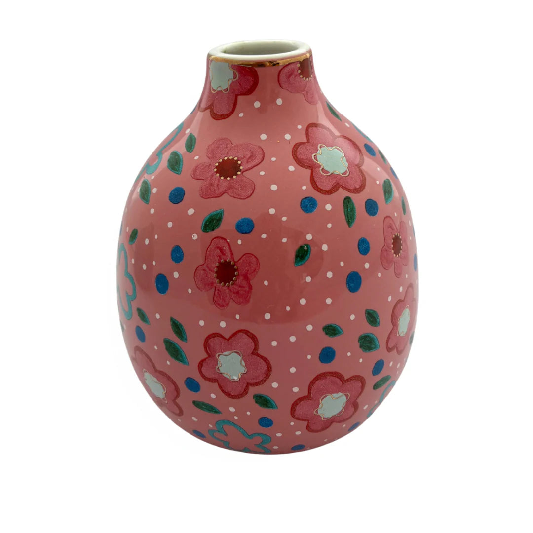 Pink ceramic vase with floral patterns on a white background