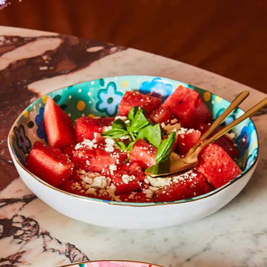 Bowl of watermelon salad with feta and mint on a marble table