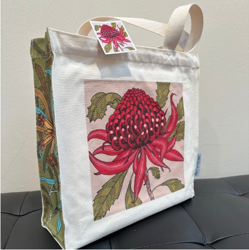 Tote bag with a red flower design on a gray surface