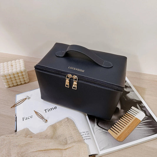 Navy toiletry bag case with gold accents on a magazine with grooming tools