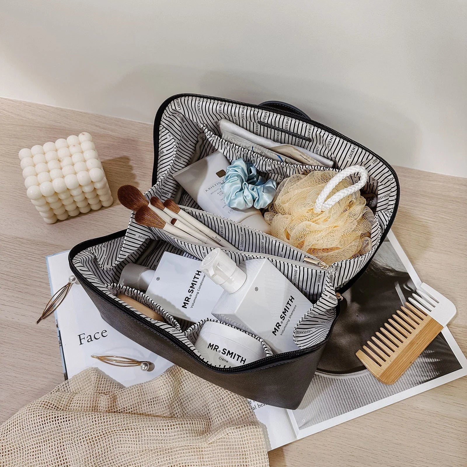 Open travel-sized toiletry case with toiletries on a wooden surface