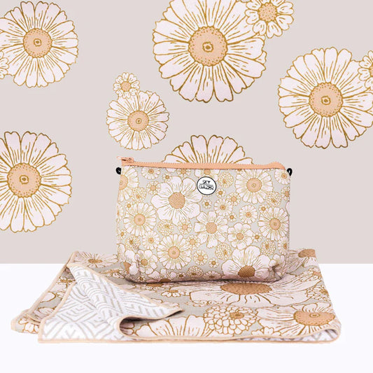 Floral-patterned pouch and beach towel on a light background with floral designs.