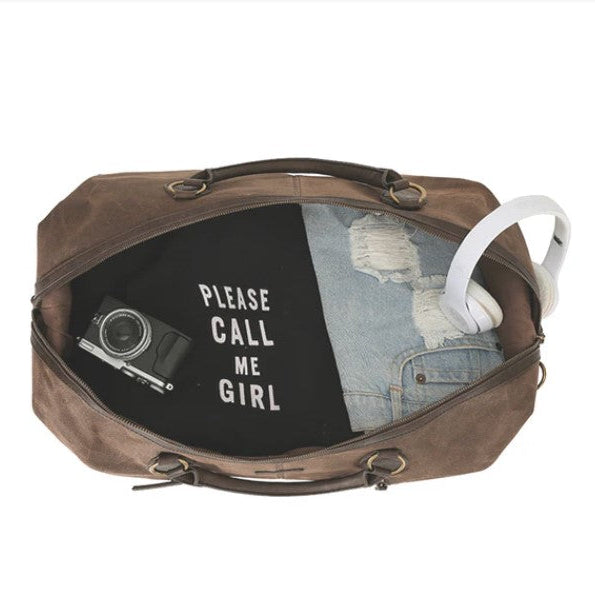 Brown leather bag with camera, denim jacket, and headphones on a white background
