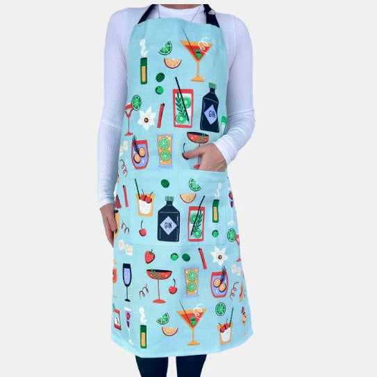Person wearing a light blue apron with colorful cocktail illustrations on a white background