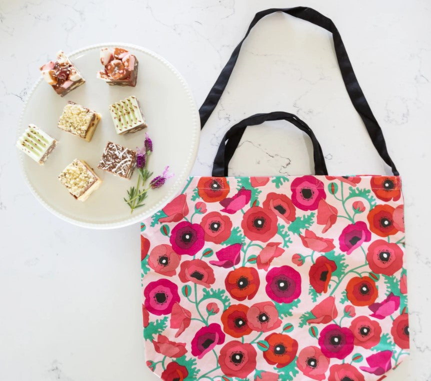 Floral tote bag with a plate of small cakes on a white surface