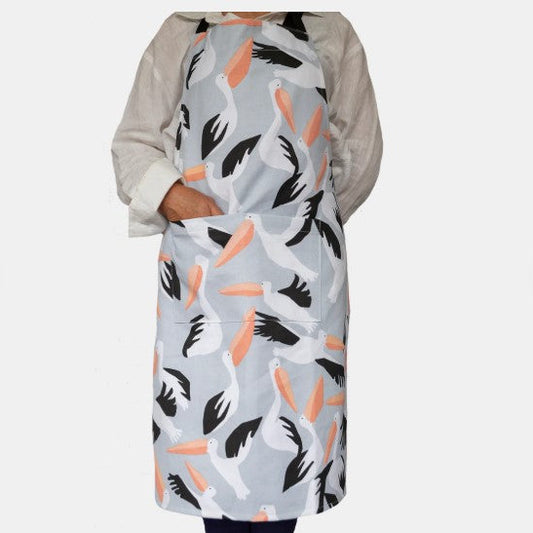 Person wearing a patterned apron with pelicans on a light gray background