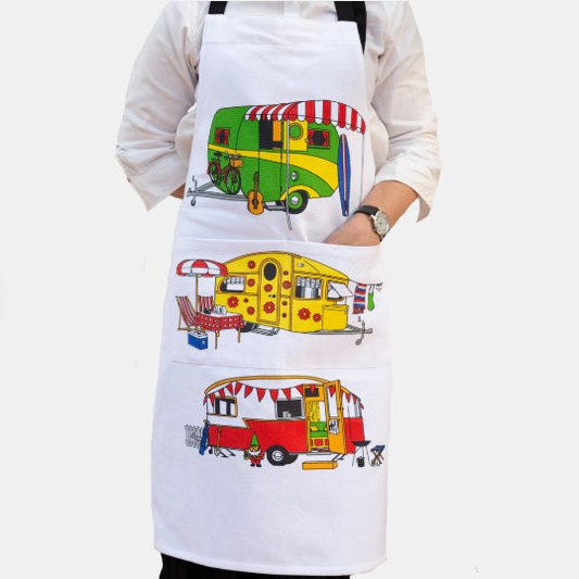 Person wearing a white apron with colorful caravan designs on a white background