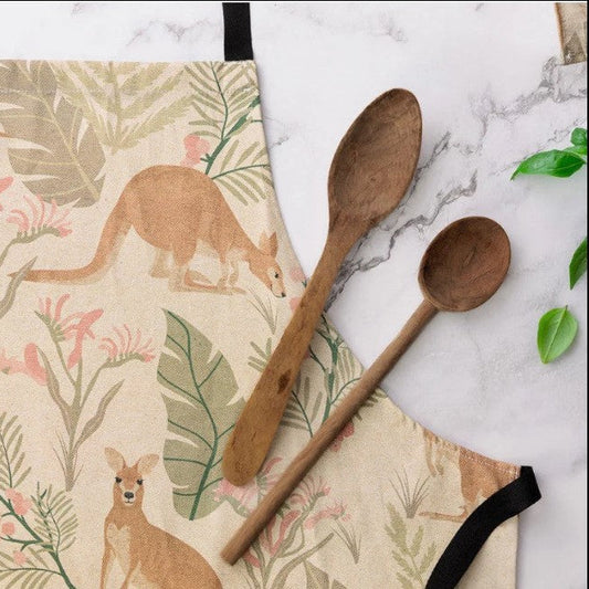 Two wooden spoons on a marble surface with a kangaroo-patterned apron.