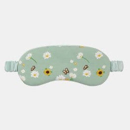A mint green sleep mask with a daisy and bumblebee floral pattern, featuring elasticized ear loops, shown against a light gray background.