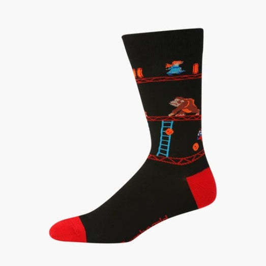 A single crew sock with a black body featuring a retro video game level design with a brown bear, blue ladder, and red/orange platforms, finished with red toe and heel sections.