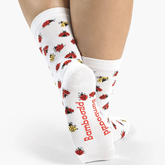White socks with ladybug pattern worn by a person on a white background