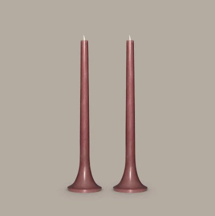 Two tall, thin, pink candles on a beige background