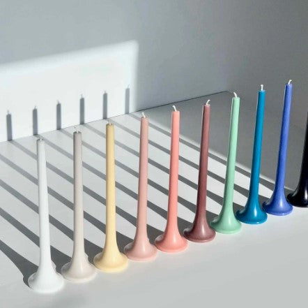 Set of colorful candles on a white surface with a gray background