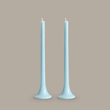 Two light blue candles on a beige background