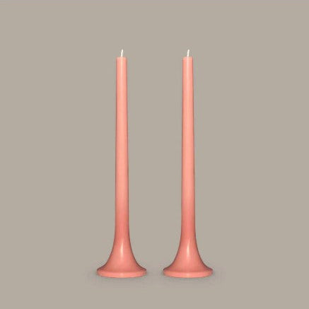 Two pink candles on a beige background