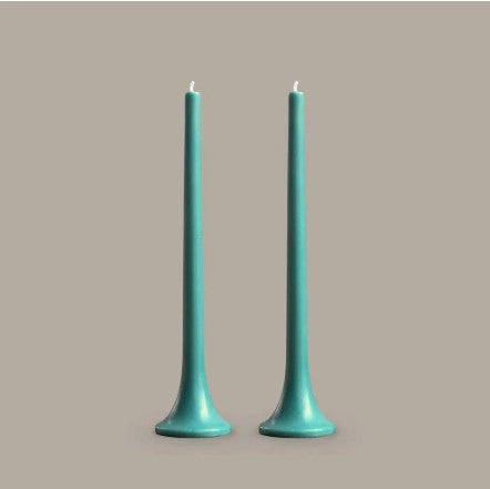 Two teal candles on a beige background