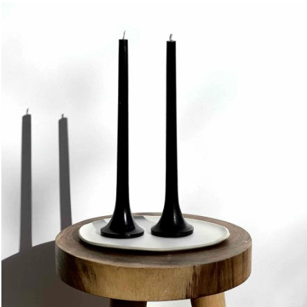 Black candles on a wooden stool with a white background