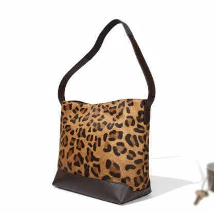 Leopard print handbag with black base on a white background