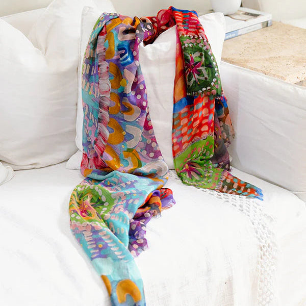 Colorful patterned scarf draped over a white sofa