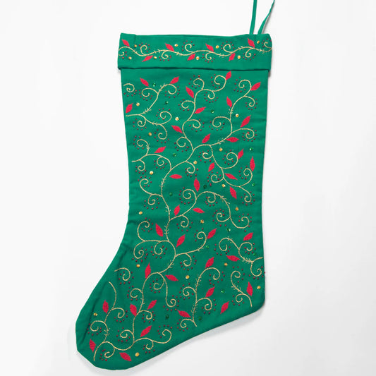 Green Christmas stocking with decorative patterns on a white background