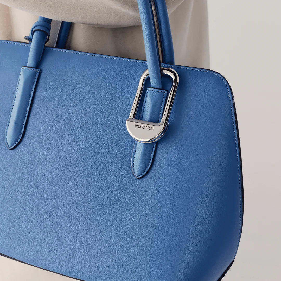 Blue handbag with a silver Clip on a neutral background