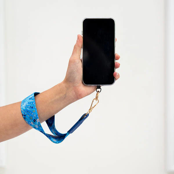 Hand holding a smartphone with a blue strap against a white background