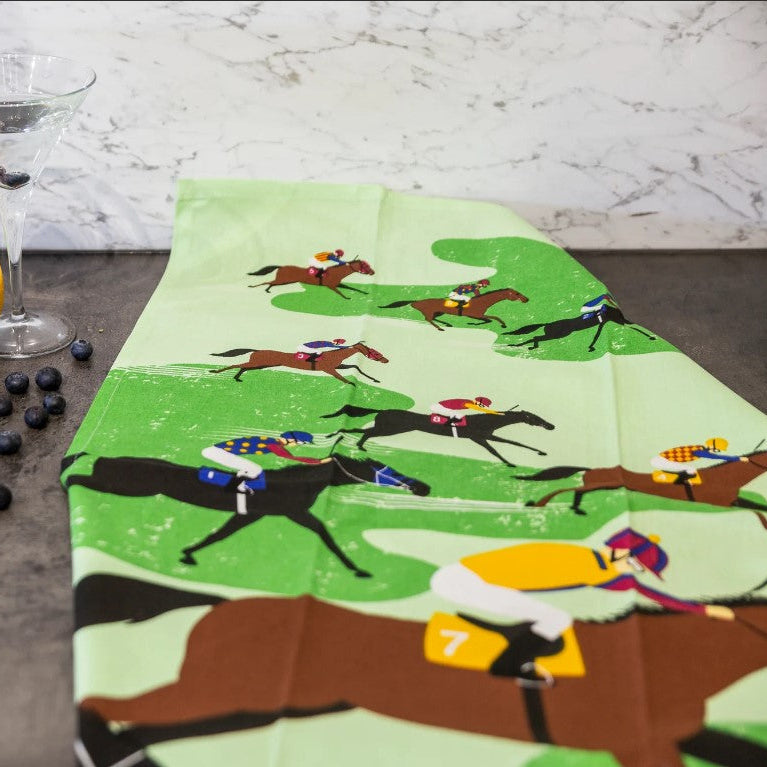 Tea towel with horse racing design on a marble surface