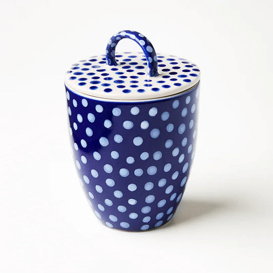 Blue ceramic jar with white polka dots on a white background