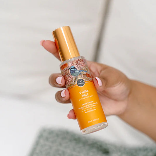 Hand holding a vanilla-flavored body mist.