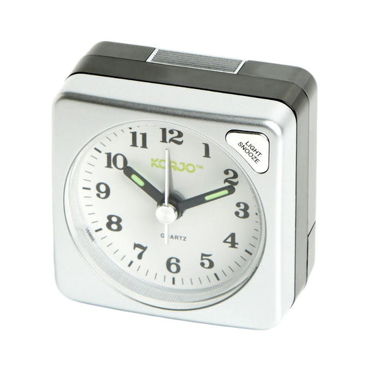 Silver alarm clock with white face on a white background