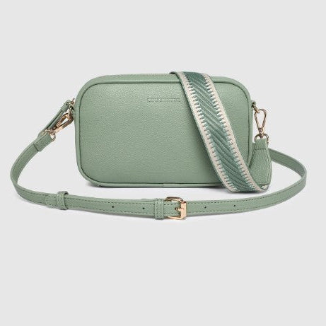 Green crossbody bag with a strap on a light gray background